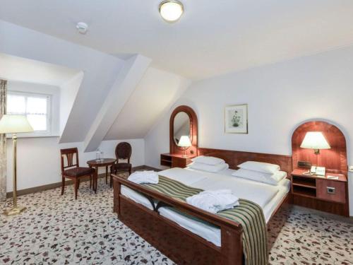 a hotel room with a bed and a table and chairs at Mercure Grand Hotel Biedermeier Wien in Vienna