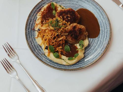 a blue plate of food with noodles and meatballs at Mercure Grand Hotel Biedermeier Wien in Vienna