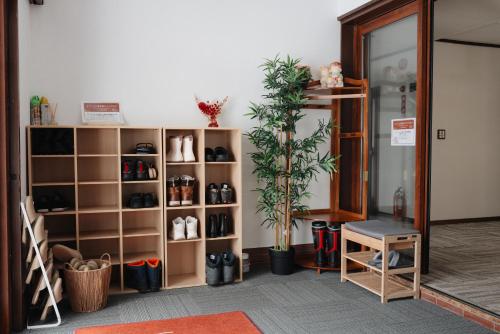 a room with a shelf with shoes and a plant at 雪场缆车站旁-汤泽雪の宿-Ski IN Ski OUT-全新装修 in Seki