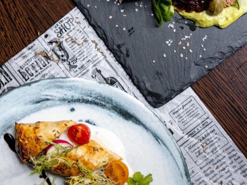 a plate of food with a slice of pizza on it at Hotel Mercure Wien Westbahnhof in Vienna