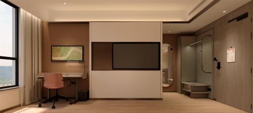 a room with a tv and a desk and a chair at Hilton Garden Inn Lanzhou Anning in Lanzhou