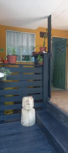 a porch with potted plants and a green door at Cabañas Iisi in Hanga Roa