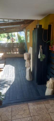 a porch with a wooden floor with a shower and logs at Cabañas Iisi in Hanga Roa