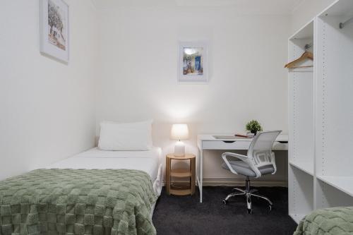 a bedroom with a bed and a desk and a chair at StayCentral - Cityviews on City Road Southbank in Melbourne