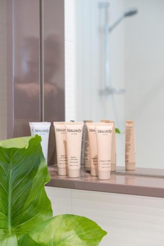 a row of cups sitting on a shelf next to a plant at StayCentral - Cityviews on City Road Southbank in Melbourne
