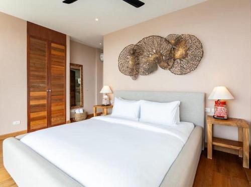 a bedroom with a large white bed in a room at Tahiana Villa in Haad Tian