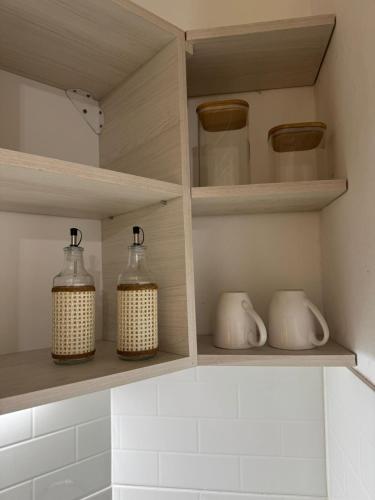 four glass jars are sitting on shelves in a kitchen at Departamento Bonito Excelente Ubicación in Morón