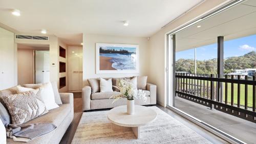 a living room with a couch and a table at Surf N Turf in Kiama
