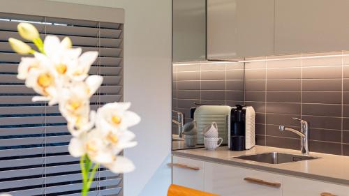 a kitchen with a sink and a vase of flowers at Surf N Turf in Kiama