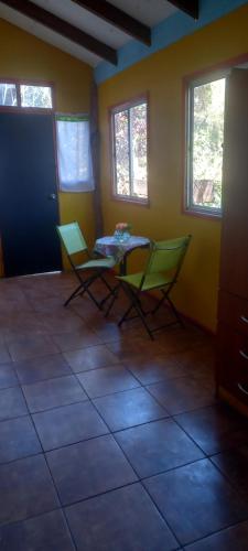 a room with two chairs and a table in it at Cabañas Iisi in Hanga Roa