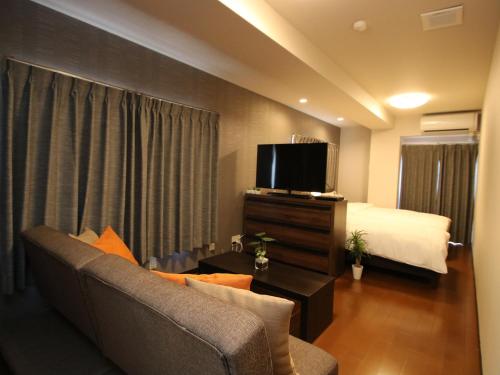 a hotel room with a couch and a bed and a tv at SA in Nagano Ishido - Vacation STAY 10215v in Nagano