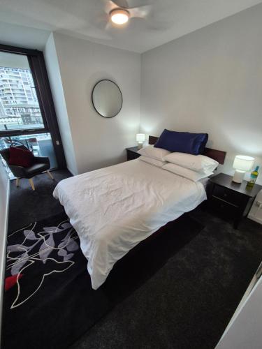 a bedroom with a large bed and a window at Private Bedroom & Bathroom in an Amazing Shared Brisbane Apartment in Brisbane