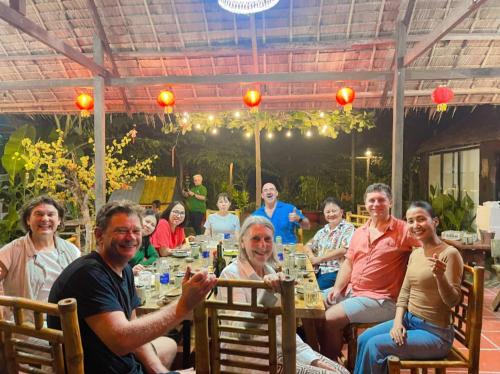 a group of people sitting around a table at Khu nghỉ dưỡng sinh thái Apsara Sóc Trăng in Ấp Vĩnh Hưng