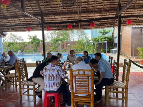 a group of people sitting at a table in a restaurant at Khu nghỉ dưỡng sinh thái Apsara Sóc Trăng in Ấp Vĩnh Hưng