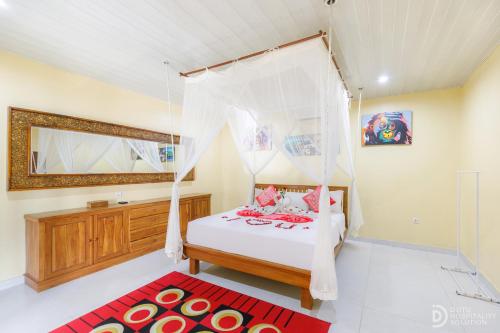 a bedroom with a bed and a red rug at Pondok Kutuh Guest House in Ubud