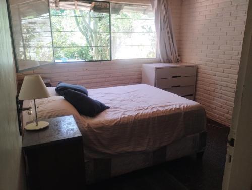 a small bedroom with a bed and a window at Hostal Blancarena in Colonia Rosario