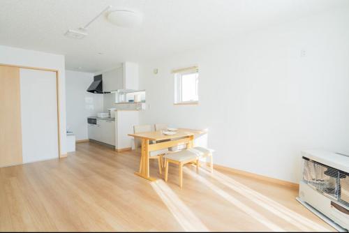 a living room with a table and a kitchen at Niseko Yu Villa A in Niseko