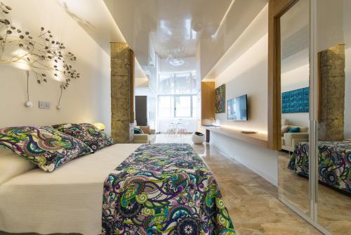 a bedroom with a large bed and a living room at Suites Garden Loft Roy Lichtenstein in Las Palmas de Gran Canaria