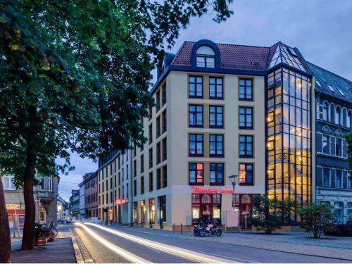 a building on a city street with a street at Mercure Hotel Erfurt Altstadt in Erfurt