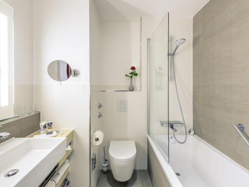 a bathroom with a toilet and a sink and a shower at Mercure Hotel Erfurt Altstadt in Erfurt