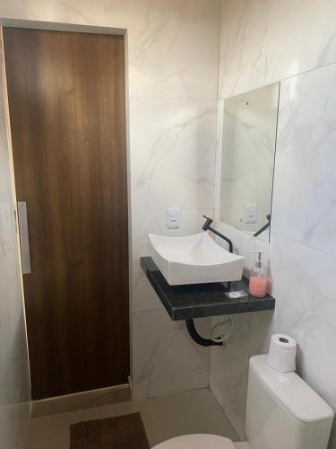 a bathroom with a sink and a toilet and a mirror at Apt estiloso 02 in Paragominas