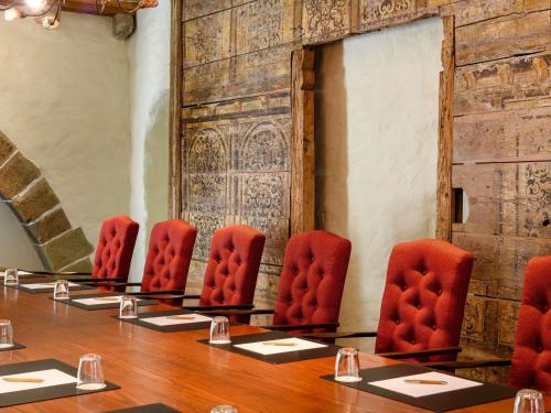 a meeting room with red chairs and a table at Mercure Hotel Erfurt Altstadt in Erfurt