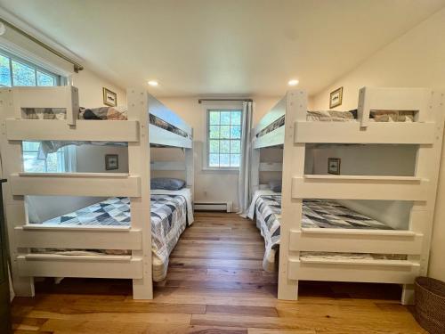 two bunk beds in a room with wooden floors at The Brewster Pearl in Brewster