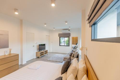 a bedroom with a large bed and a flat screen tv at Sleep With Sheep - 3 Bedroom Pool Villa in Chiang Mai