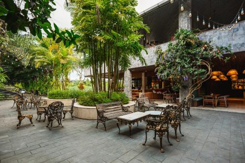 ONYX PARK RESORT Ubud في أوبود: فناء في الهواء الطلق مع كراسي وطاولات وأشجار