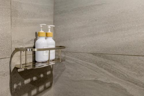 a shelf with three bottles of soap on a wall at Sleep With Sheep - 3 Bedroom Pool Villa in Chiang Mai