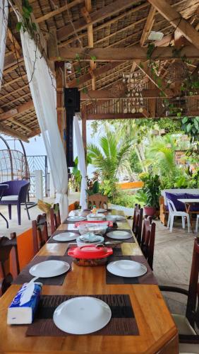 a long wooden table with white plates on it at Chue&larry's Beachside Homestay in Libagon