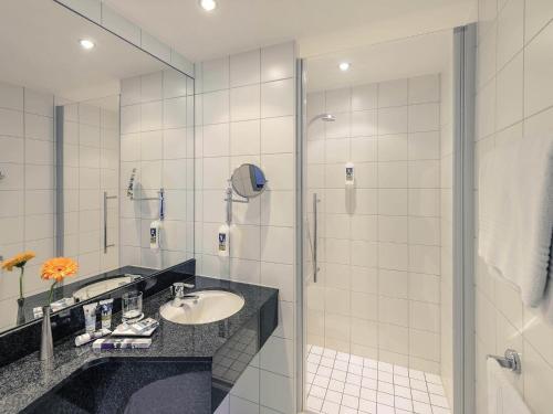 a bathroom with a sink and a shower at Mercure Neu-Isenburg in Neu Isenburg