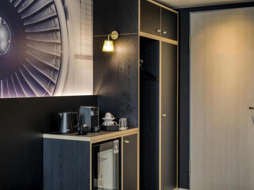 a kitchen with black walls and a counter with appliances at Mercure Neu-Isenburg in Neu Isenburg
