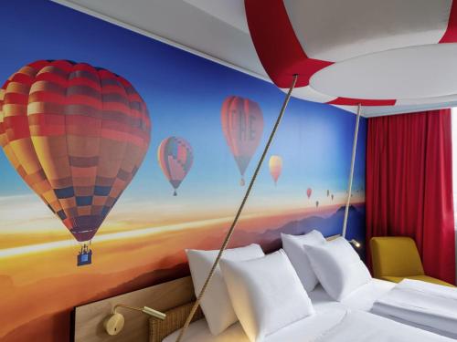 a bedroom with a mural of hot air balloons at Mercure Neu-Isenburg in Neu Isenburg