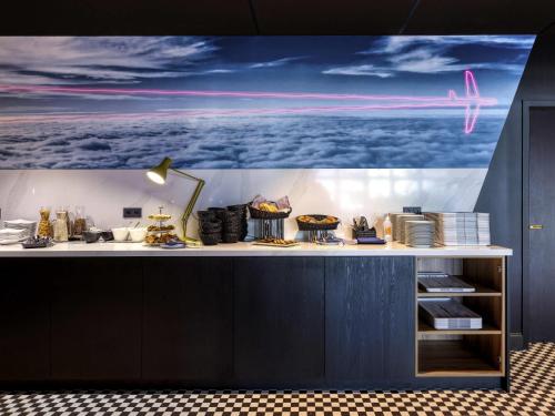 a counter with a picture of an airplane on the wall at Mercure Neu-Isenburg in Neu Isenburg