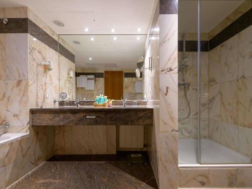 a bathroom with a large sink and a shower at Novotel Freiburg am Konzerthaus in Freiburg im Breisgau