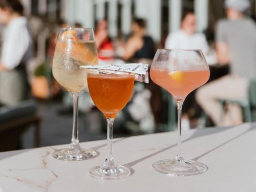 three wine glasses sitting on top of a table at Kimpton Theta New York - Times Square by IHG in New York