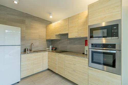 a kitchen with stainless steel appliances and wooden cabinets at Sleep With Sheep - 3 Bedroom Pool Villa in Chiang Mai
