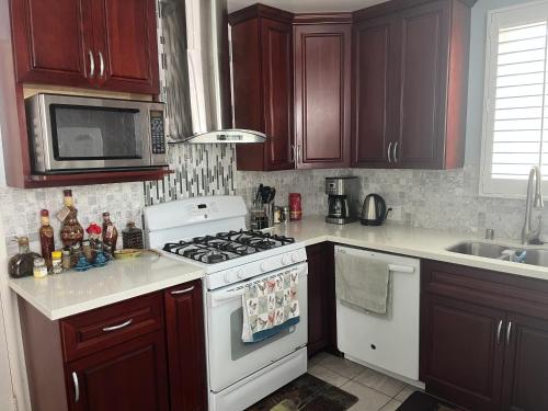 a kitchen with wooden cabinets and a white stove top oven at 2 Bedroom House OR Private Studio near SF, SFSU and SFO in Daly City