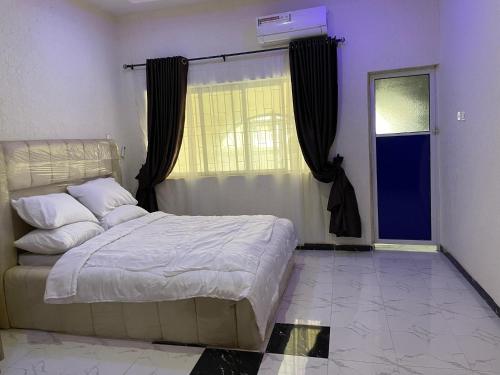 une chambre avec un grand lit et une fenêtre dans l'établissement Grace Guest Home, à Aro