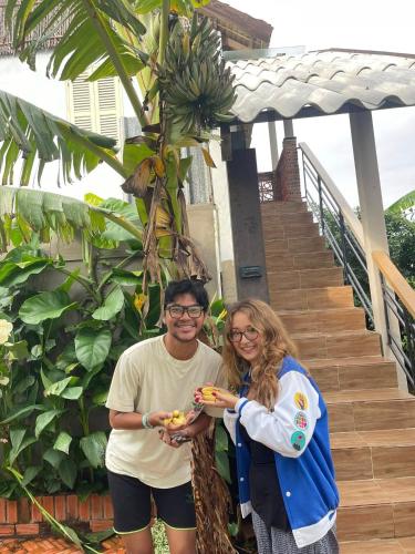 a man and woman standing next to a banana tree at Khu nghỉ dưỡng sinh thái Apsara Sóc Trăng in Ấp Vĩnh Hưng