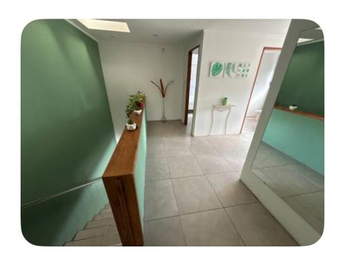 a hallway with green walls and a tile floor and a mirror at Acantilados mar y pileta in Mar del Plata