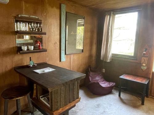 a room with a wooden table and a window at Cabañas en el Bosque a 5 minutos del mar - Estancia CH in Punta del Este