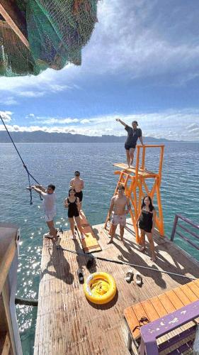 a group of people standing on a dock in the water at Chue&larry's Beachside Homestay in Libagon