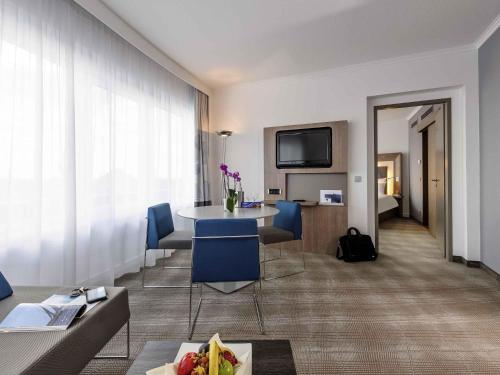 a hotel room with a table and chairs and a room at Novotel Hannover in Hannover