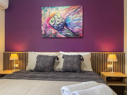 a bedroom with a bed with a purple wall at Quarterdeck Apartments in Gladstone