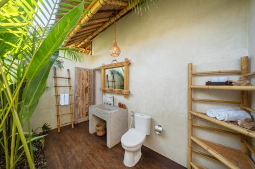 a bathroom with a toilet and a sink at Rumah Kita Ecolodge in Ubud