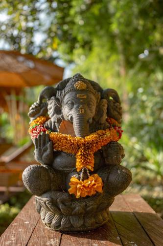 a statue of an elephant sitting on a table at Rumah Kita Ecolodge in Ubud
