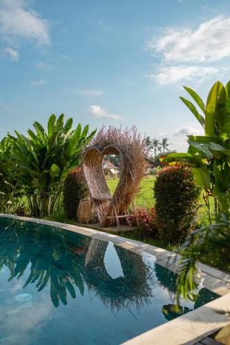 a sculpture of a heart next to a swimming pool at Rumah Kita Ecolodge in Ubud