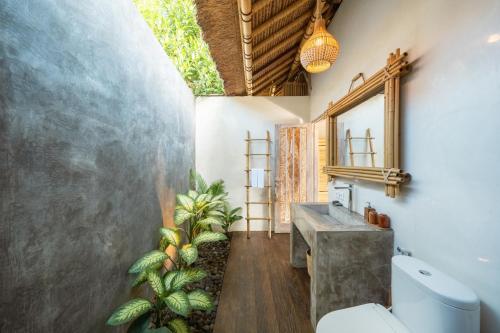 a bathroom with a sink and a mirror at Rumah Kita Ecolodge in Ubud